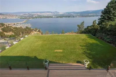 a large green field with a view of a lake at Lake and Bridge View Vacation Home in West Kelowna