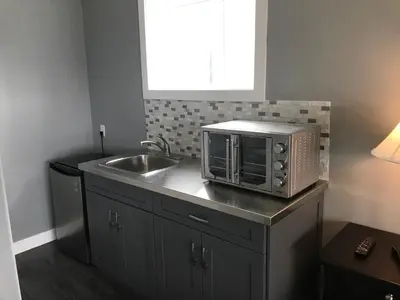 a kitchen with a sink and a microwave on a counter at Lake and Bridge View Vacation Home in West Kelowna