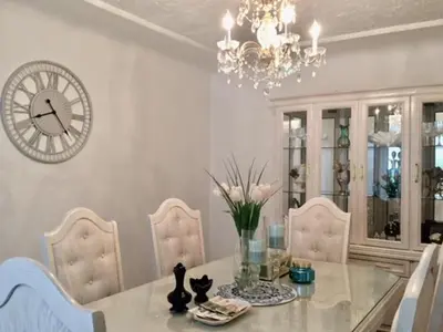 a dining room with a table and a clock on the wall at Lee home in Vancouver