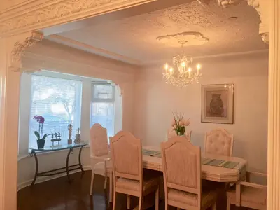 a dining room with a table and chairs and a chandelier at Lee home in Vancouver
