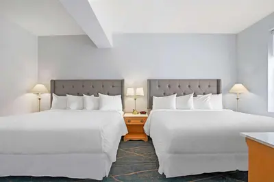 two beds in a hotel room with white pillows at Crown Columbia Hotel; BW Premier Collection in Trail