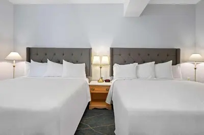 two beds in a hotel room with white sheets at Crown Columbia Hotel; BW Premier Collection in Trail