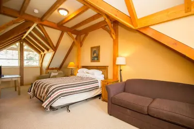 a bedroom with a bed and a couch at 3 BR 3 Bath ski in ski out with private hot tub in Big White