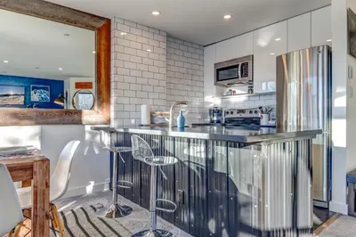 a kitchen with a counter and a refrigerator at THE LOOKOUT PENTHOUSE // a luxe suite in Whistler in Whistler