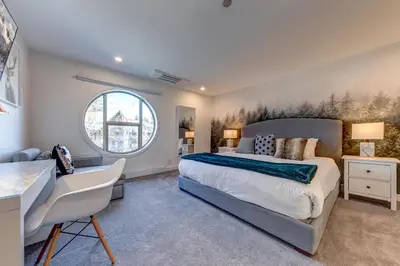 a bedroom with a large bed and a window at THE LOOKOUT PENTHOUSE // a luxe suite in Whistler in Whistler