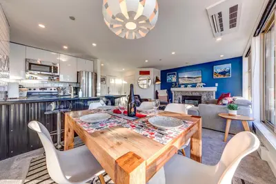a kitchen and dining room with a wooden table and chairs at THE LOOKOUT PENTHOUSE // a luxe suite in Whistler in Whistler