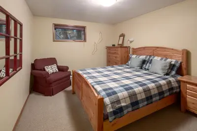 a bedroom with a bed and a chair at Falcon Cabin in Fairmont Hot Springs