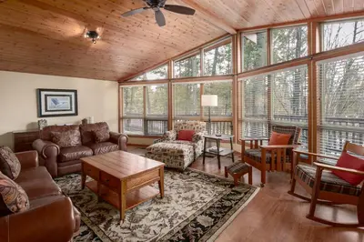a living room filled with furniture and windows at Falcon Cabin in Fairmont Hot Springs