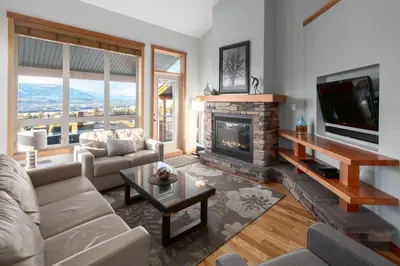 a living room with a fireplace and a tv at The Residences at Fairmont Ridge in Fairmont Hot Springs