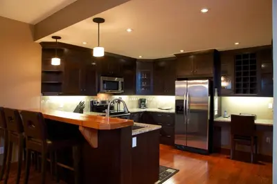 a kitchen with wooden cabinets and a sink and a refrigerator at The Residences at Fairmont Ridge in Fairmont Hot Springs