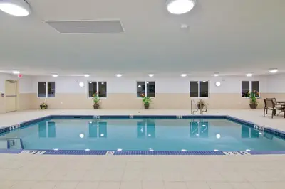 a large swimming pool with blue water in a building at Wingate by Wyndham Fort Saskatchewan in Fort Saskatchewan