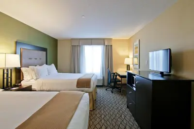 a hotel room with two beds and a flat screen tv at Wingate by Wyndham Fort Saskatchewan in Fort Saskatchewan