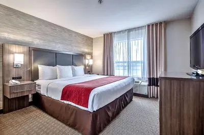 a hotel room with a large bed and a television at Comfort Inn & Suites South in Calgary
