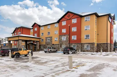 a large building with cars parked in a parking lot at Comfort Inn & Suites in Red Deer