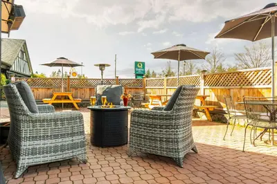 a patio with chairs and tables and umbrellas at Quality Inn Waddling Dog in Saanichton