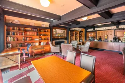 a library with a table and chairs and bookshelves at Quality Inn Waddling Dog in Saanichton