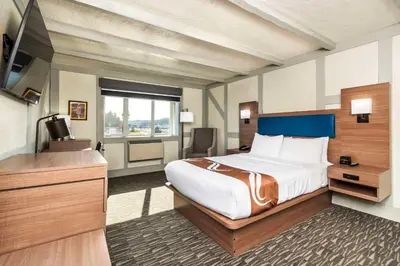 a hotel room with a bed and a television at Quality Inn Waddling Dog in Saanichton
