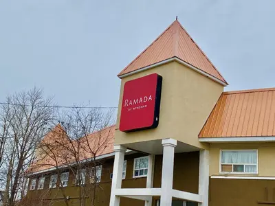 a building with a sign on the side of it at Ramada by Wyndham Whitecourt in Whitecourt
