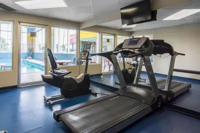 a gym with two tread machines and a swimming pool at Comfort Inn & Suites Airport South in Calgary
