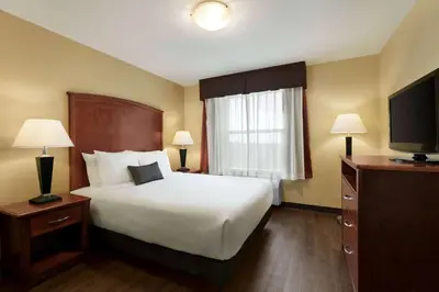 a hotel room with a bed and a television at Days Inn & Suites by Wyndham Sherwood Park Edmonton in Sherwood Park