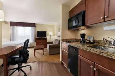 a kitchen with a sink and a desk in a room at Days Inn & Suites by Wyndham Sherwood Park Edmonton in Sherwood Park