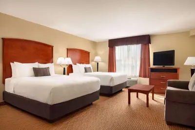 a hotel room with two beds and a television at Days Inn & Suites by Wyndham Sherwood Park Edmonton in Sherwood Park