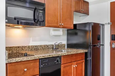 a kitchen with a sink and a microwave at Days Inn & Suites by Wyndham Sherwood Park Edmonton in Sherwood Park