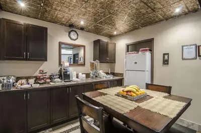 a kitchen with a table with a bowl of fruit on it at Econo Lodge Lloydminster in Lloydminster