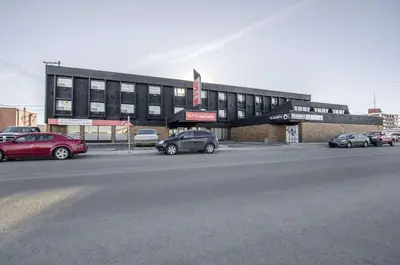a parking lot with cars parked in front of a building at Econo Lodge Lloydminster in Lloydminster