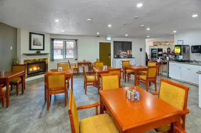 a restaurant with tables and chairs and a fireplace at Econo Lodge Inn & Suites High Level in High Level
