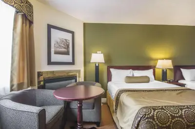 a hotel room with a bed and a table and chairs at Econo Lodge Inn & Suites High Level in High Level