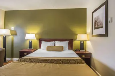 a bedroom with a bed with two nightstands and two lamps at Econo Lodge Inn & Suites High Level in High Level