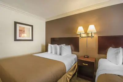 a hotel room with two beds and two lamps at Quality Inn & Suites High Level in High Level