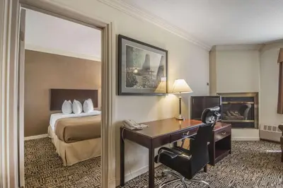 a hotel room with a desk and a bed at Quality Inn & Suites High Level in High Level