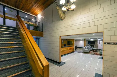 a lobby with stairs in a building with a waiting room at Prestige Riverside Lodge Quesnel in Quesnel