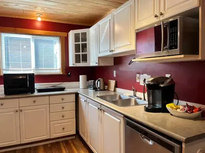 a kitchen with white cabinets and a sink at Frigon Suite -Waterfront in Port Alice