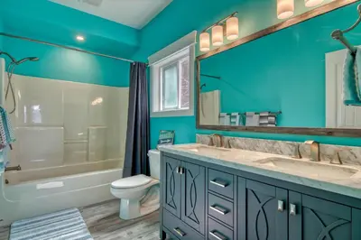 a blue bathroom with a tub and a toilet and a sink at Semi-Lakefront Luxury Retreat In Blind Bay, Bc Cottage in Blind Bay
