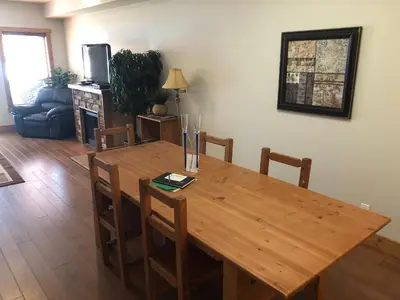 a wooden table in a living room with a table and chairs at Lakefront Townhouse Family Complex, Popular Wine Country and the Best Golfing in Osoyoos