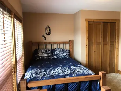 a bedroom with a bed with a blue comforter at Lakefront Townhouse Family Complex, Popular Wine Country and the Best Golfing in Osoyoos
