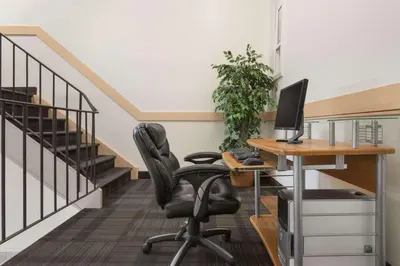 an office with a desk and a computer monitor at Travelodge by Wyndham Calgary South in Calgary