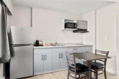 a kitchen with a table and a refrigerator at The Vista Inn in Kamloops