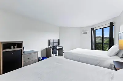 a hotel room with two beds and a desk at The Vista Inn in Kamloops