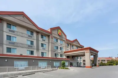 a hotel with a building with a clock on it at Super 8 by Wyndham Abbotsford BC in Abbotsford