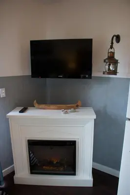 a fireplace with a tv on top of it at Brown's Bay Resort in Campbell River