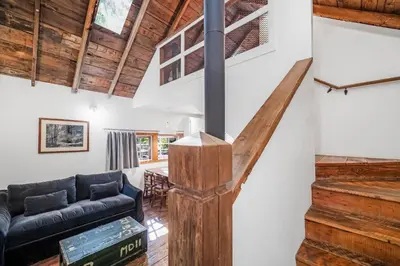 a living room with a staircase and a couch at Sunwolf Riverside Cabins in Brackendale