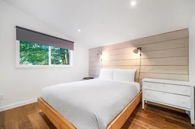a bedroom with a white bed and a window at Sunwolf Riverside Cabins in Brackendale