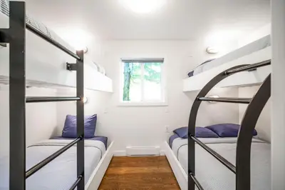 two bunk beds in a small room with a window at Sunwolf Riverside Cabins in Brackendale