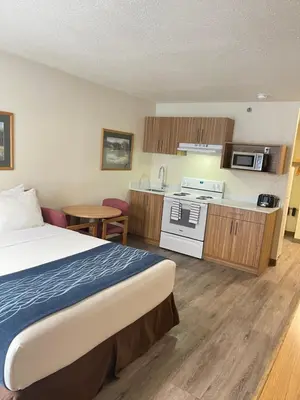a hotel room with a bed and a kitchen at Rodeway Inn in Edson