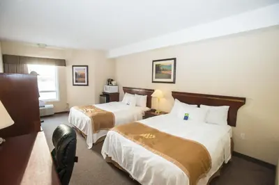 a hotel room with two beds and a window at Lakeview Inns & Suites - Chetwynd in Chetwynd