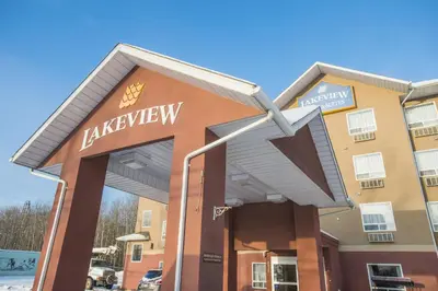 a large building with a sign for a luxury hotel at Lakeview Inns & Suites - Chetwynd in Chetwynd